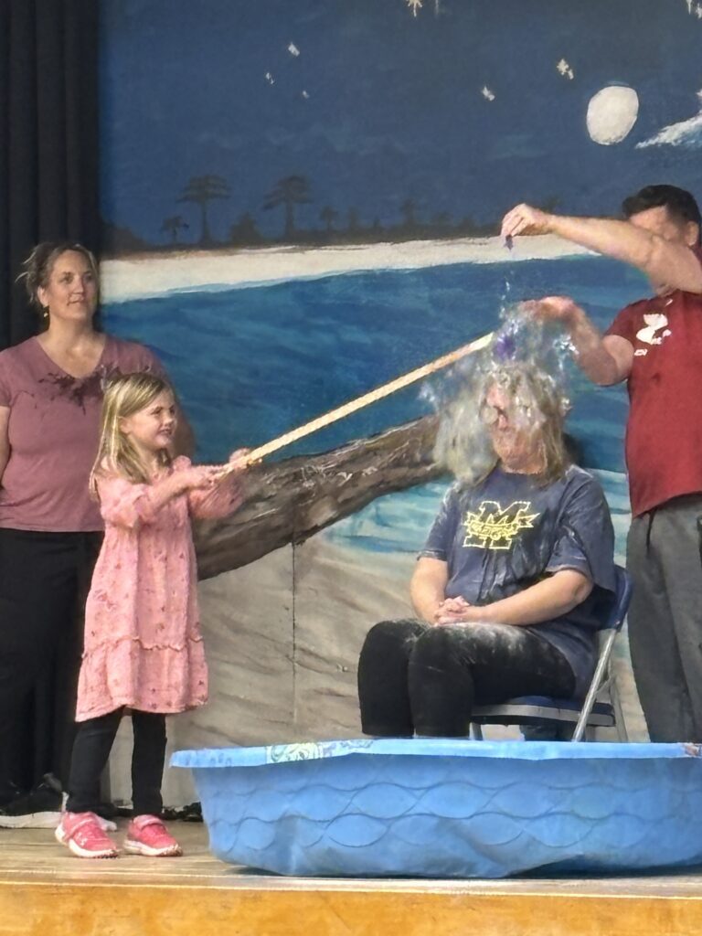 Image of teachers having balloons of stuff popped over their heads by students. 